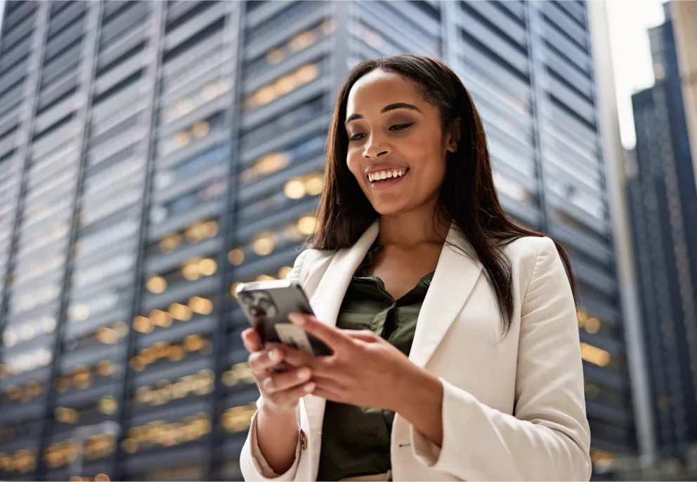 A woman looking down at her phone and smiling